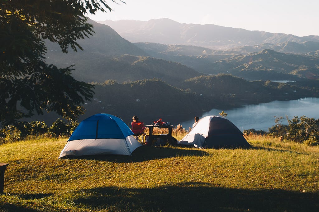 Chico en la montaña con camping