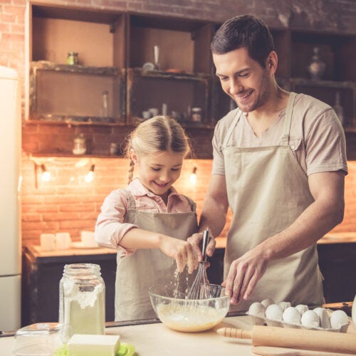 niña y padre cocinando por el dia del padre