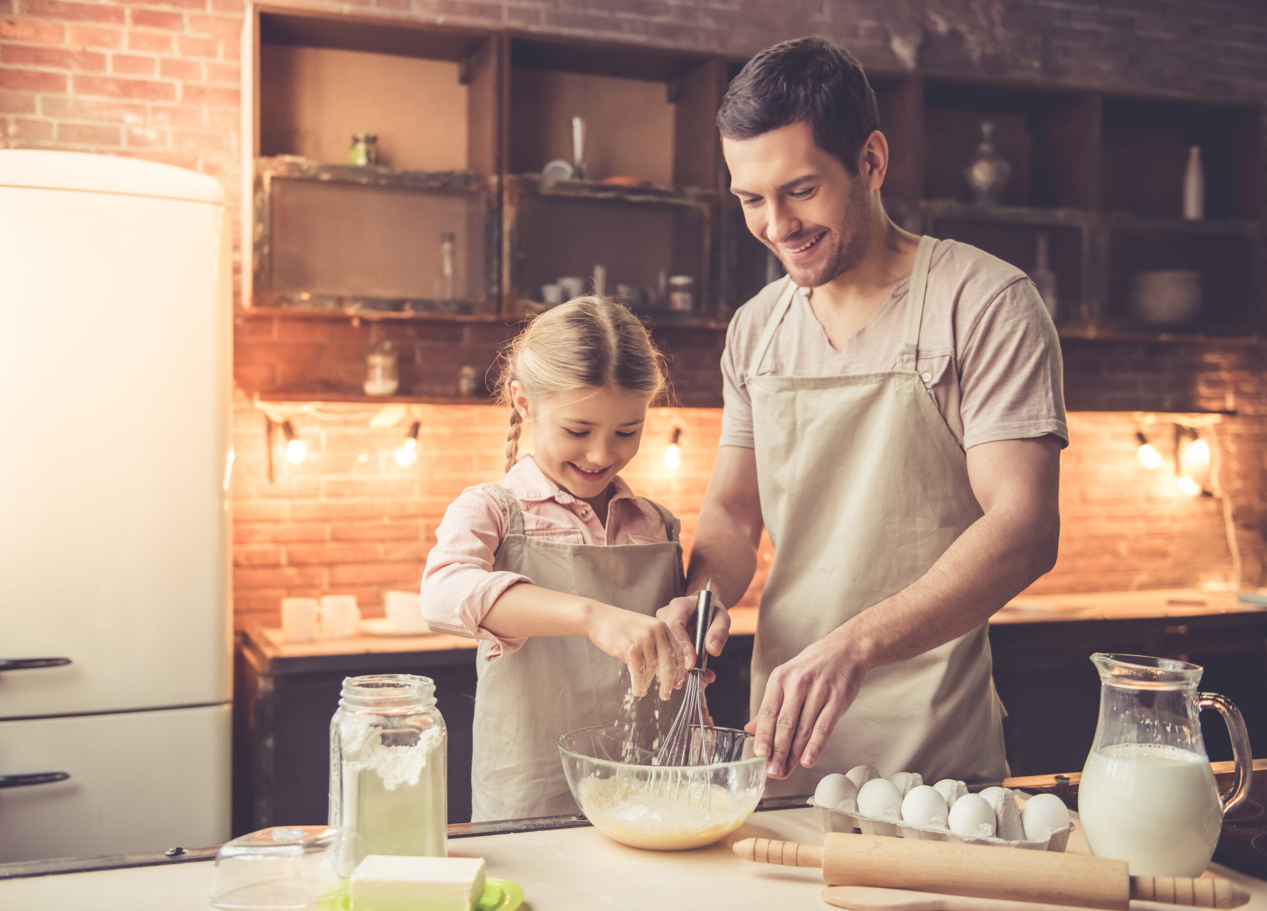 niña y padre cocinando por el dia del padre