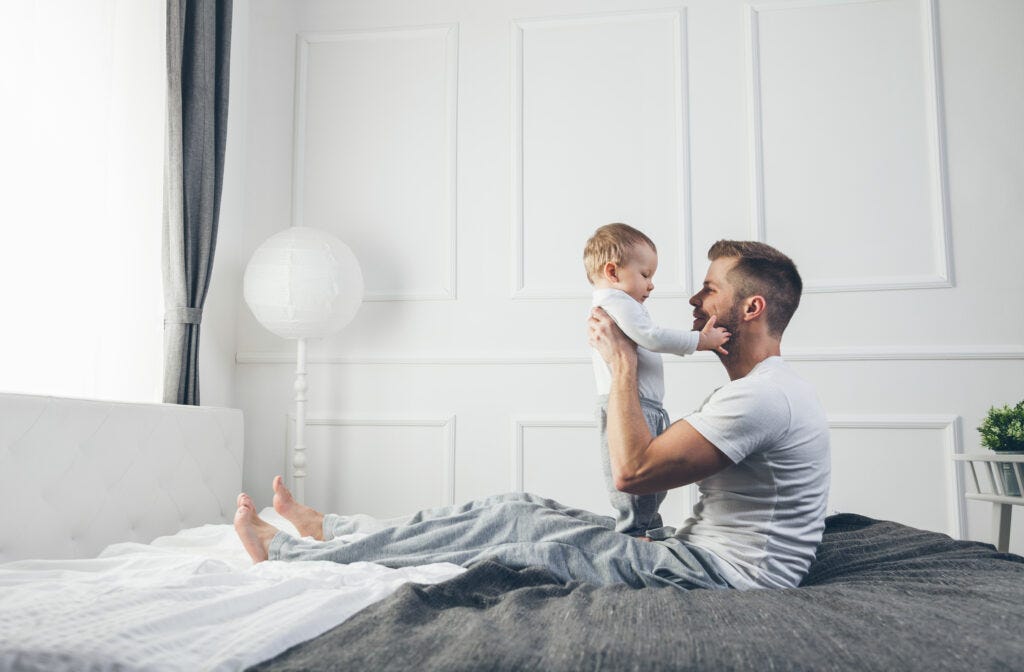 padre con su bebé en la cama