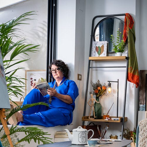 Mujer leyendo al lado de una ventana